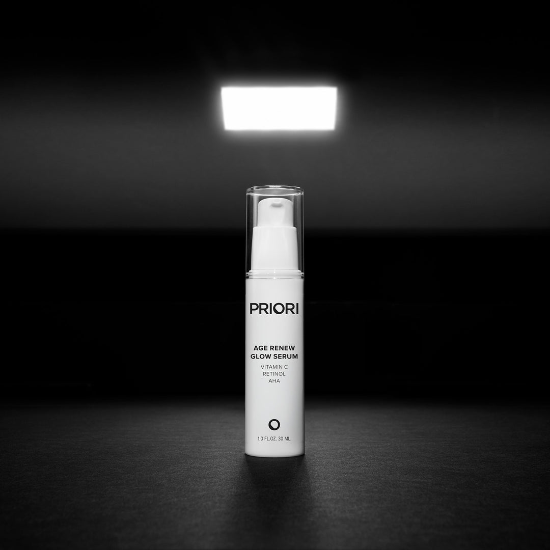 Priori Age Renew Glow Serum Anti aging cream with retinol, Vitamin C, and AHA with packaging on a black background. 3
